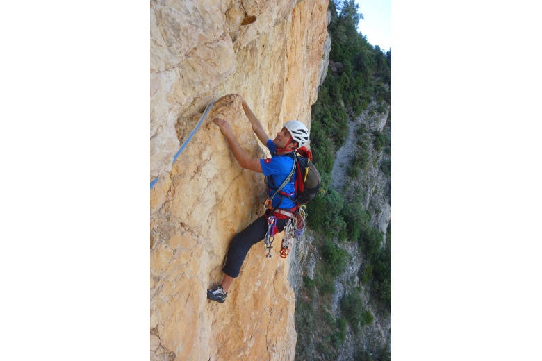 climber performing a difficult climbing step before a traverse to the left